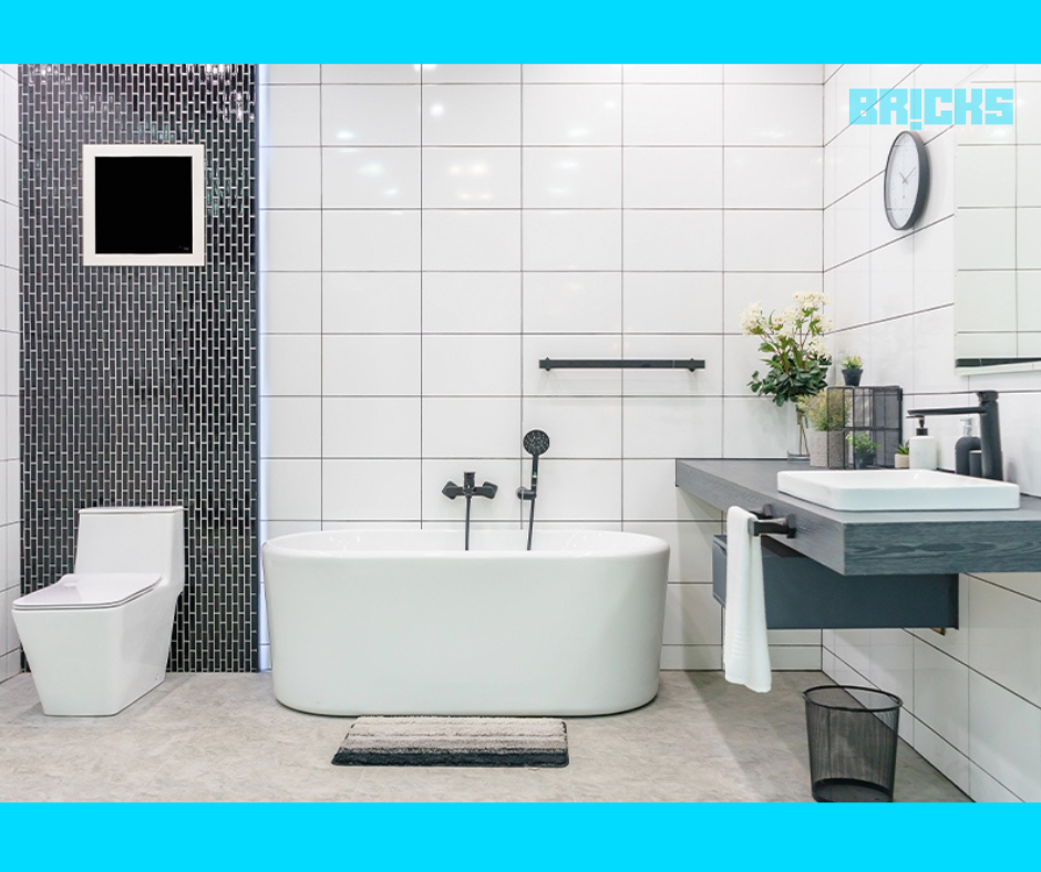 A spacious and luxurious bathroom with grey tiles and yellow lights